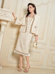 A woman stands indoors wearing the Social Queen Stretch Velvet Camisole with Embossed Lace, paired with a small matching handbag and gold high-heeled sandals.