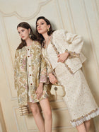 Two women pose indoors in vintage-inspired outfits: one wears the Social Queen Stretch Velvet Camisole with Embossed Lace, layered under a floral coat and dress; the other dons a cream skirt suit with embellishments, holding a matching handbag.