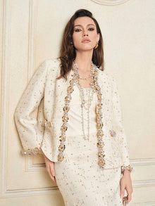 A woman poses against a cream-colored wall wearing the Social Queen Stretch Velvet Camisole with Embossed Lace, styled with layered necklaces.