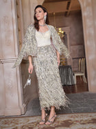 Indoors, a woman wears Social Queen's Stretch Velvet Camisole with Embossed Lace under a vintage-inspired silver fringed skirt and jacket, accessorized with a small handbag and strappy heels.