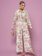 A woman wears the Social Queen Textured Embroidered Beaded Shirt with matching wide-leg pants, holding a small handbag against a pink background.