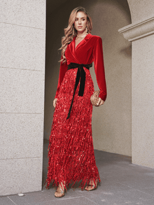 A woman wears the Social Queen Velvet Fringe Sequin Dress, featuring red velvet and sequin fringe details, styled with a gold clutch and strappy heels—ideal for making a chic statement as a wedding guest.