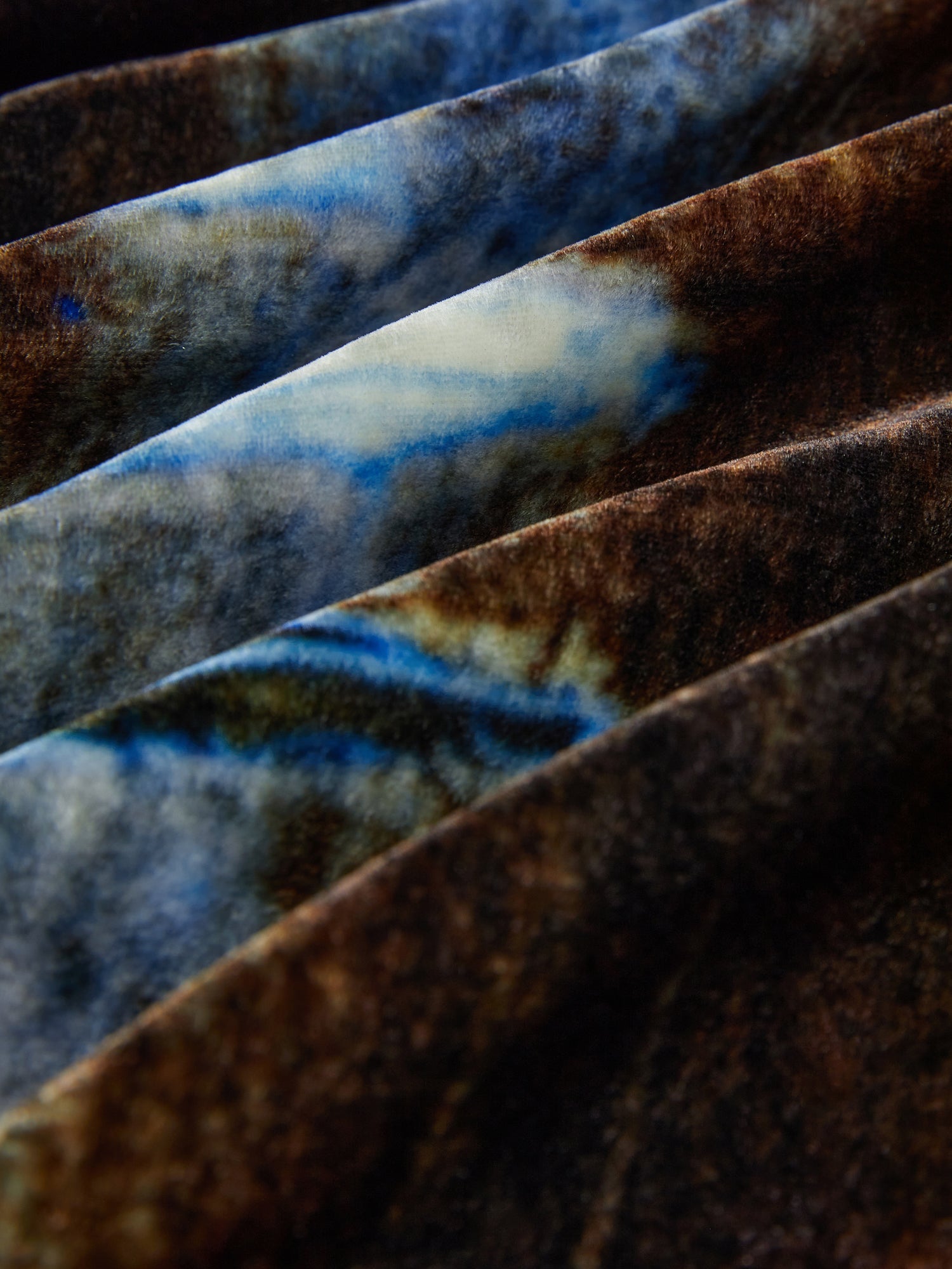 Close-up of the Social Queen Velvet Gradient Tie-Waist Trench Coat, showcasing folded fabric with a blue, brown, and white tie-dye pattern for a textured, abstract look.