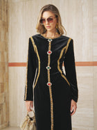 A woman in the Social Queen Velvet Jewel-Trim Dress, accessorized with a beaded handbag, sunglasses, and gold earrings.