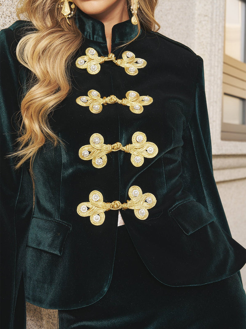 A person wearing Social Queen's Velvet Knot-Button Jacket with gold knot buttons and pearl frog closures stands near a window.