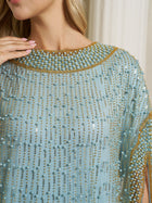 A woman wearing the Social Queen Vertical Beaded Double-Layer Caftan Dress in light blue, featuring rows of pearls and gold beading, with her hand near the collar.