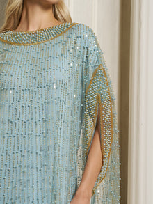 A woman wearing the Social Queen Vertical Beaded Double-Layer Caftan Dress stands by a cream-colored wall; her face is partially out of frame.