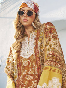 Woman wearing Social Queen's Woven Fan-Shaped Earrings, sunglasses, a headscarf, and a patterned long-sleeve dress with hand-embroidered lace details, standing against a sunlit white wall.